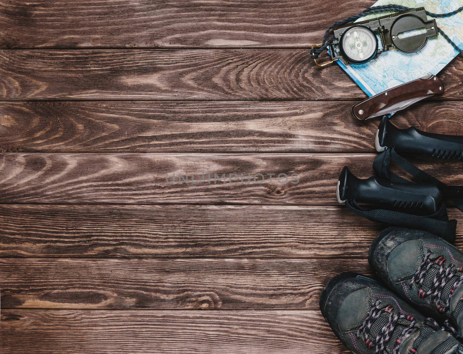 Hiking objects on a wooden background, top view. Copy-space in left part of image.