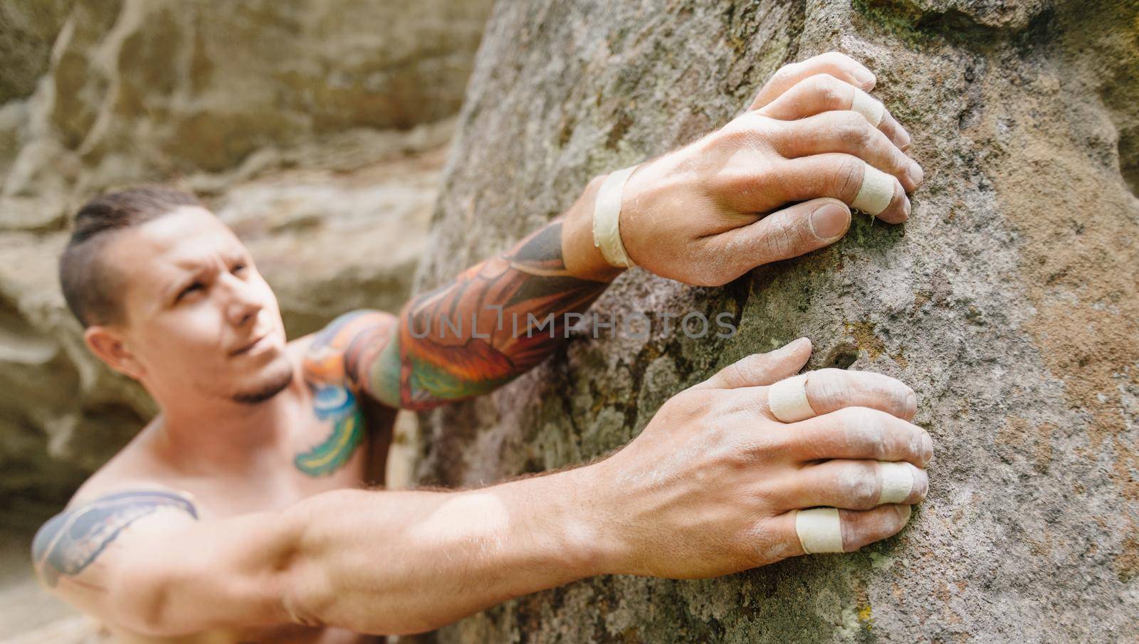 Young man climbing bouldering on rock wall.
