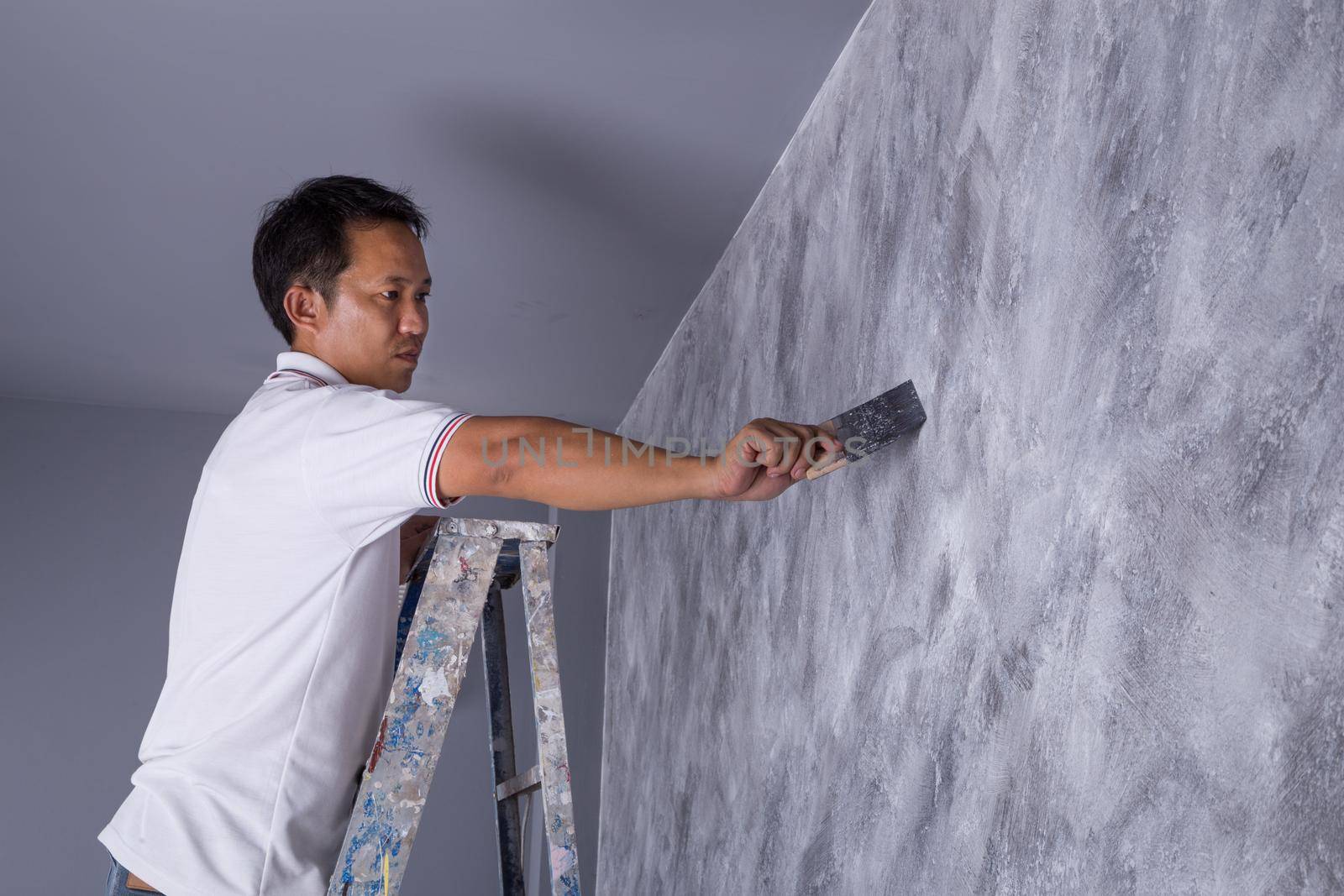 worker use brush for color paint concrete Loft style on wall of house