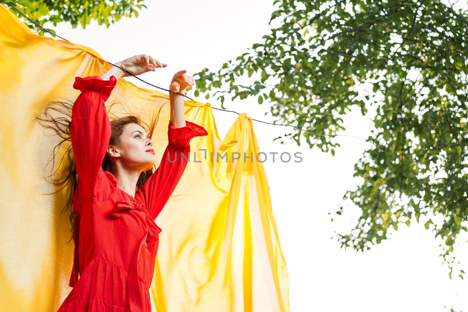 woman in red dress outdoors yellow bedspread. High quality photo