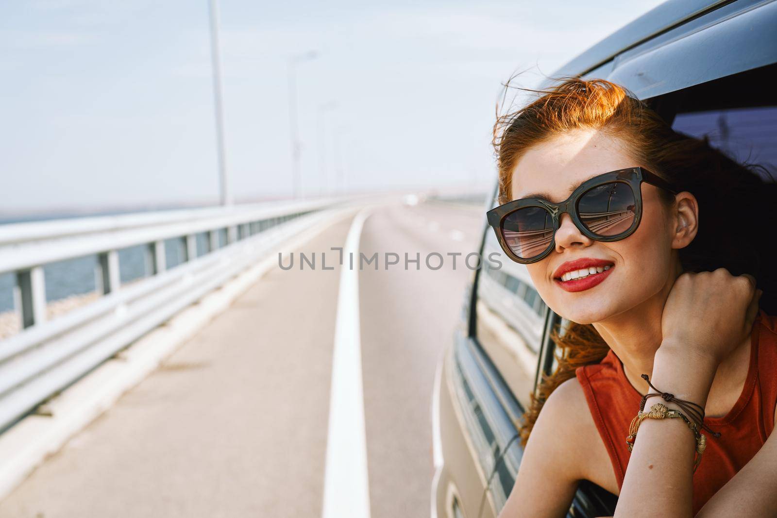 pretty woman in sunglasses rides in a travel car. High quality photo