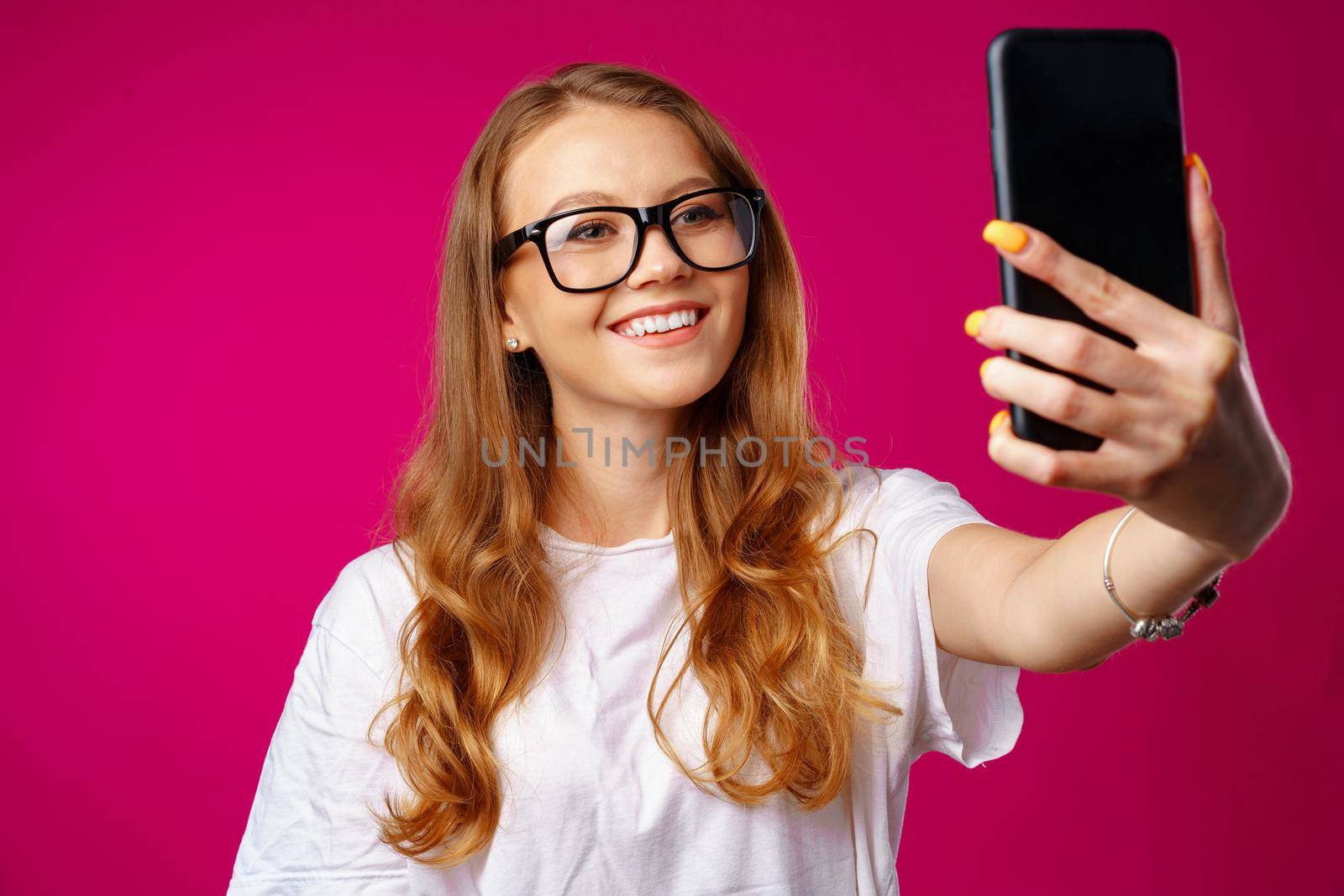 Happy casual young woman smiling and having a video call with her smartphone