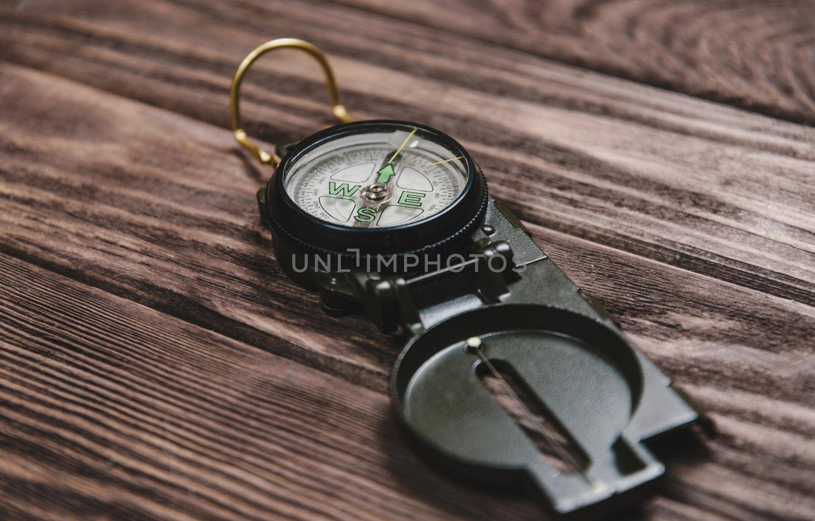 Hiking compass on a wooden background.