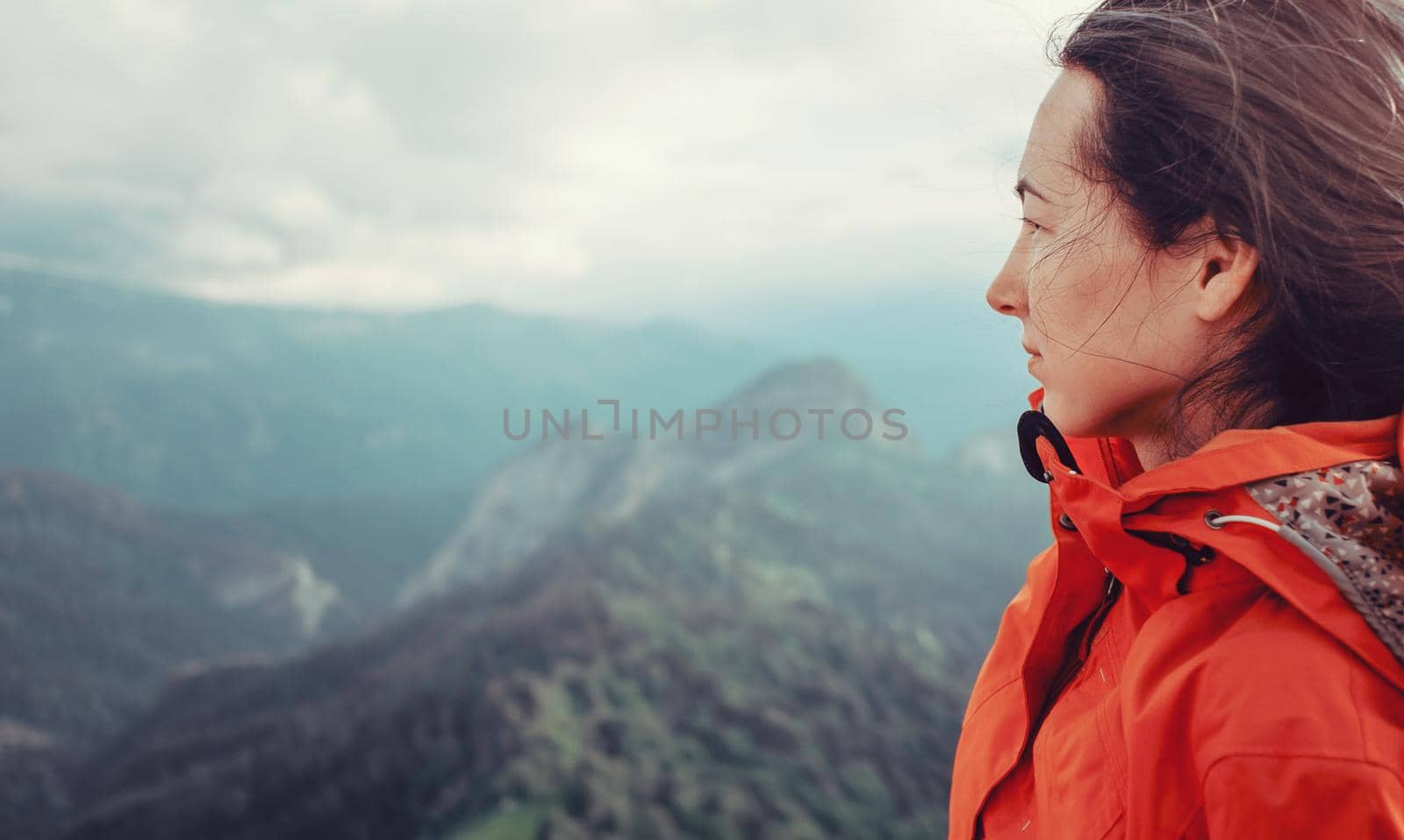 Portrait of hiker young woman on background of summer mountains.