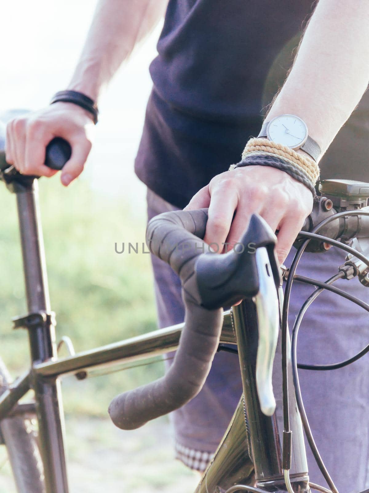 Unrecognizable young man standing with urban bike outdoor.