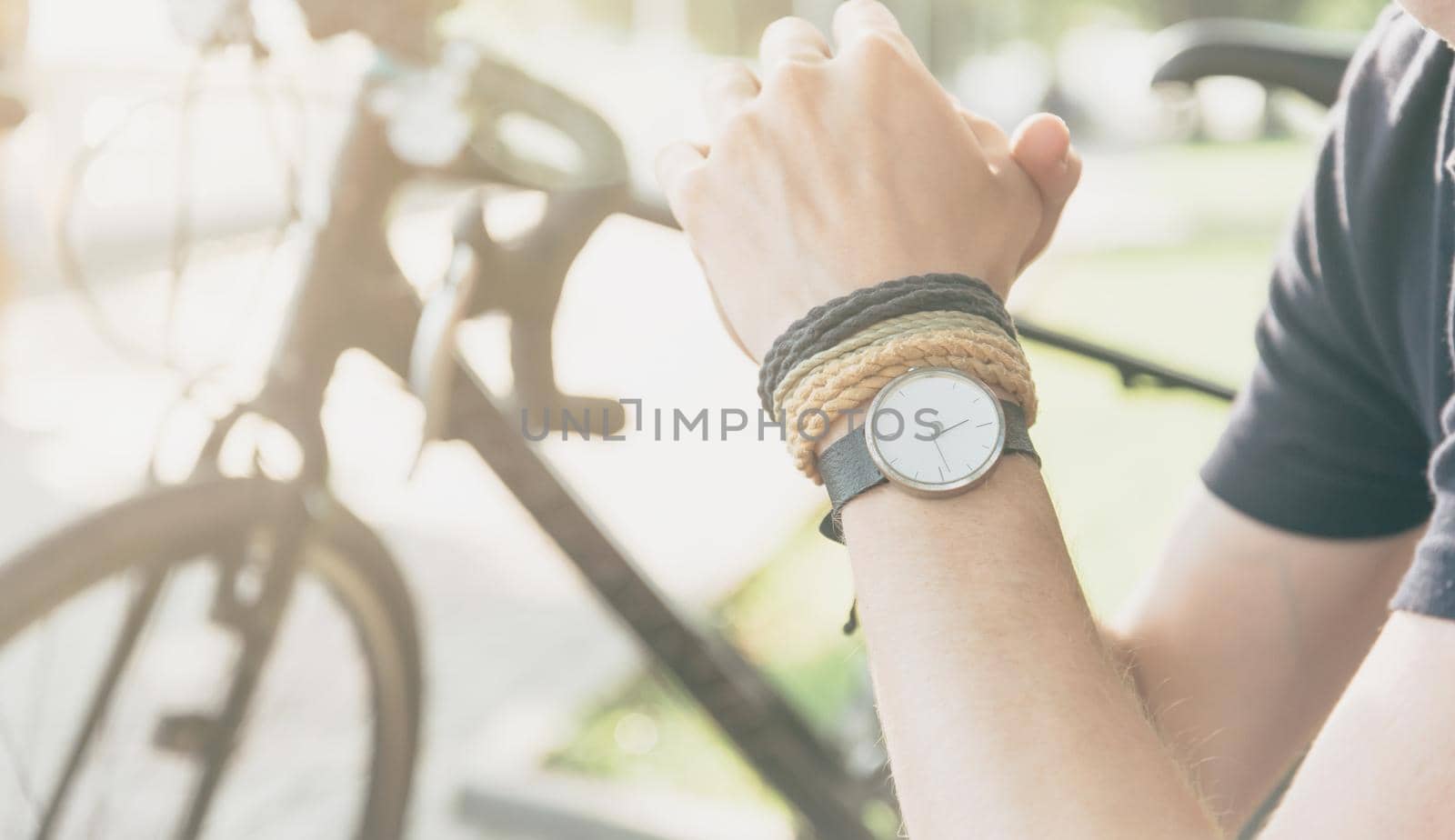 Unrecognizable man with bicycle, view of hand with watch.