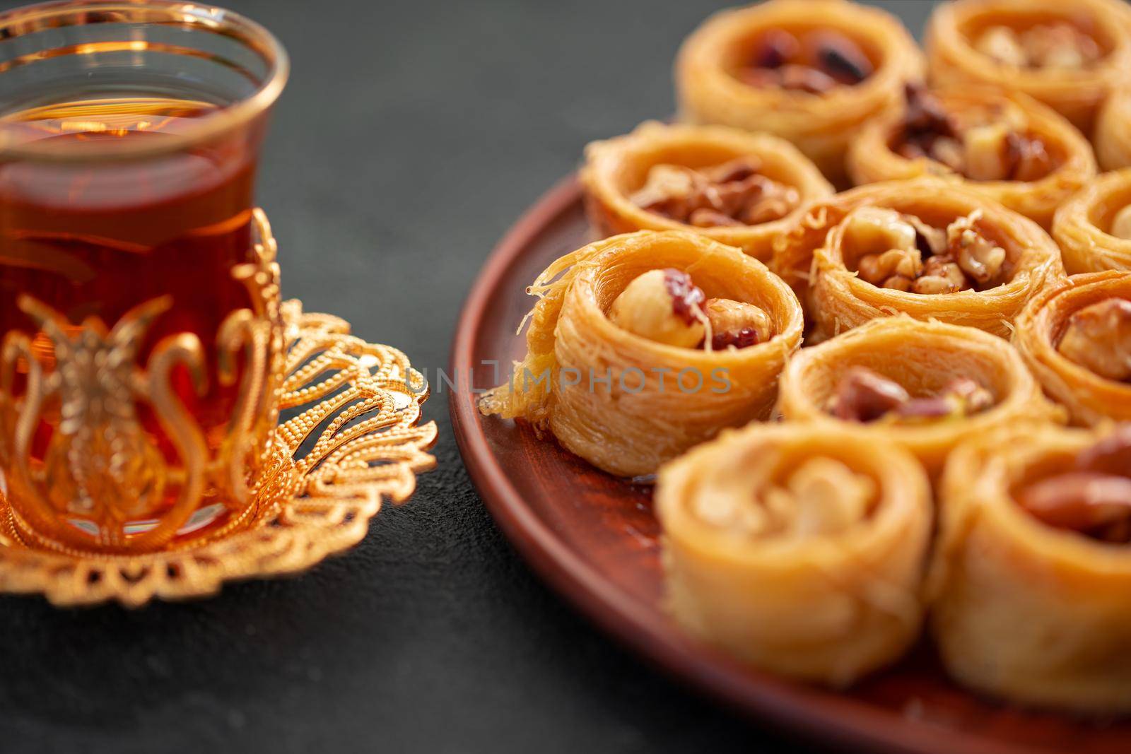 Delicious baklava dessert in oriental setting on black background, close up