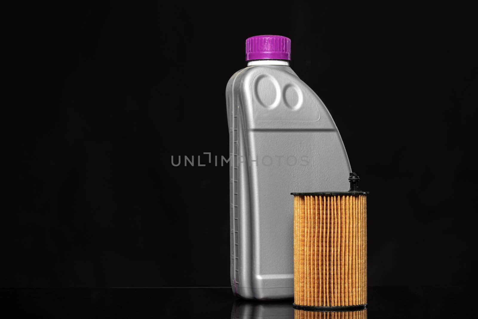 Car oil filters and motor oil can on dark background, close up.
