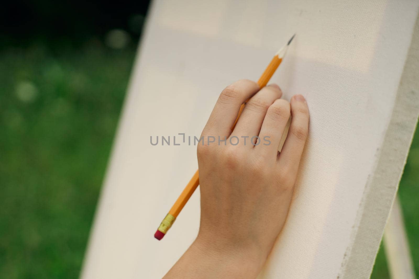 female hand with pencil easel drawing close up by Vichizh