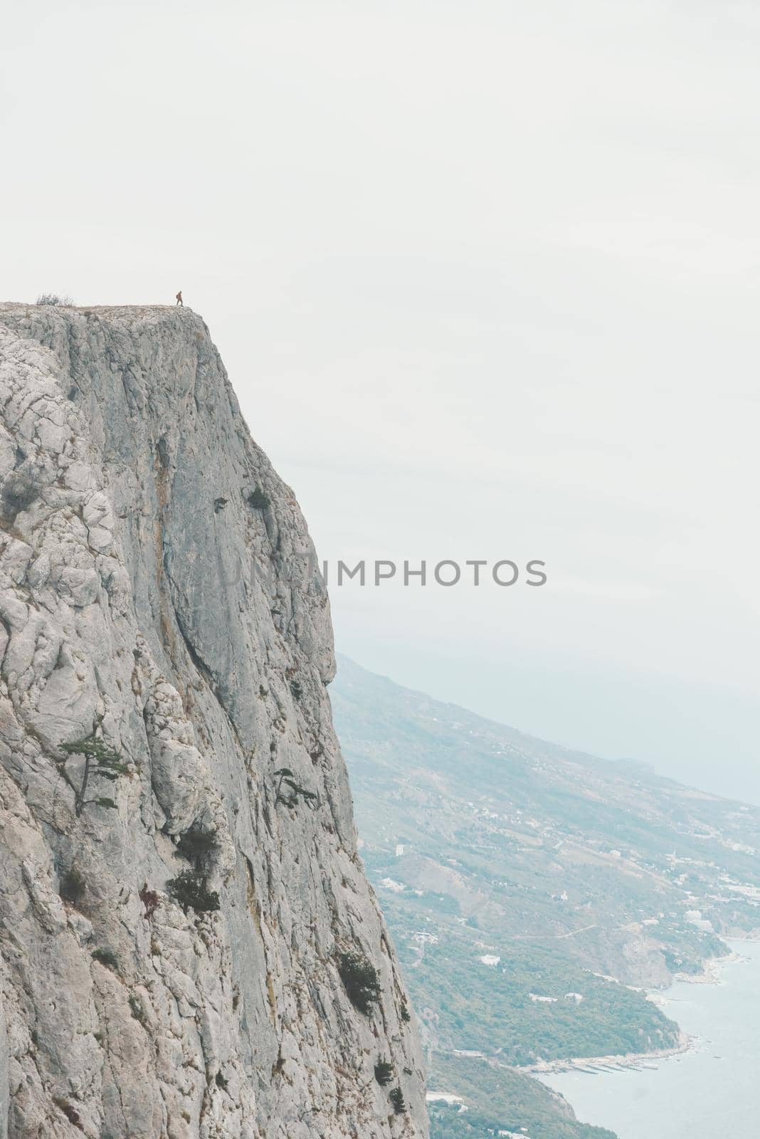 Traveler man standing on edge of cliff Foros kant over coastline, Crimea, Russia. Concept of minimal person in massive landscape.