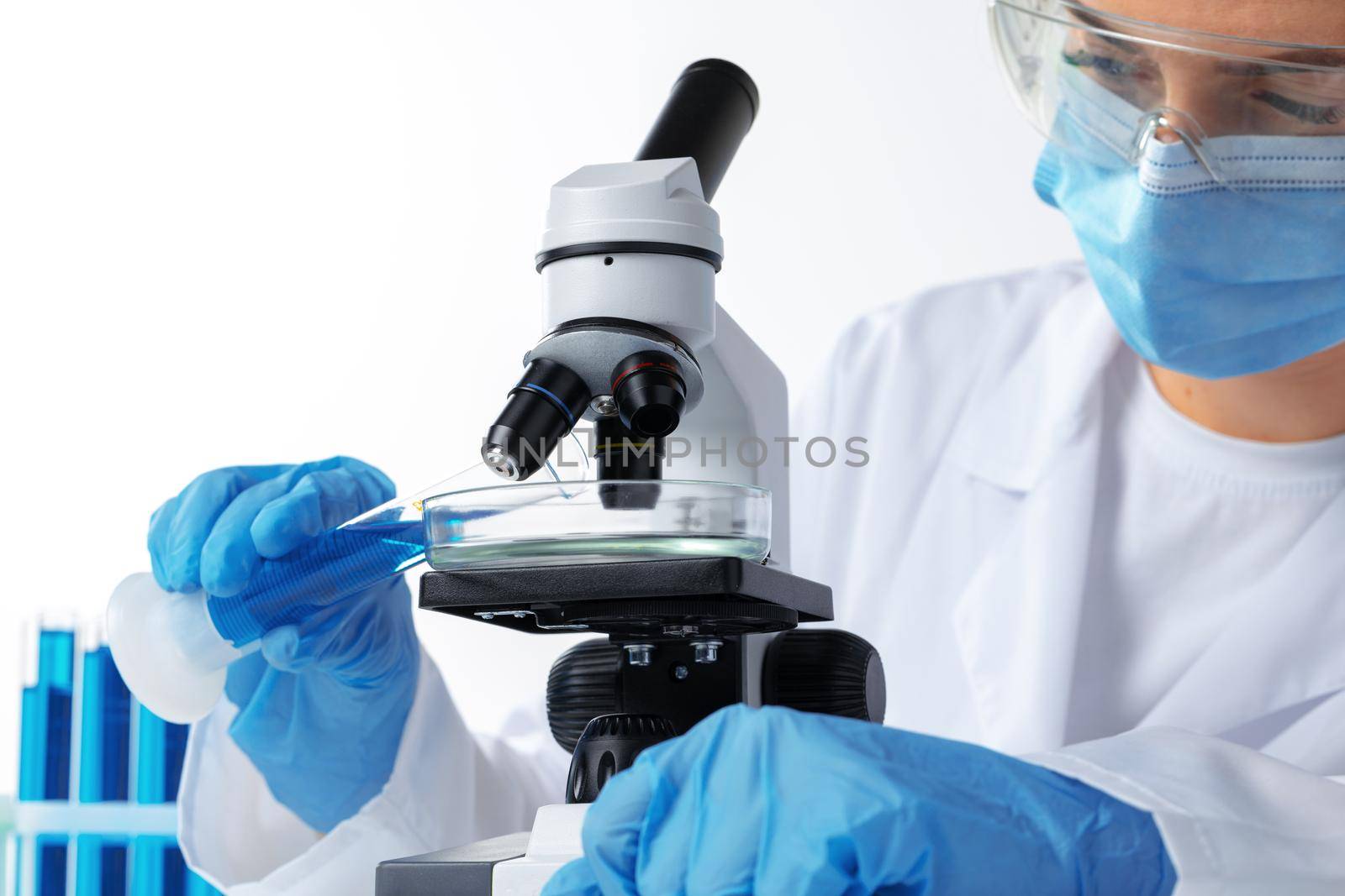 Scientist's hands doing chemical research with the help of microscope, close up