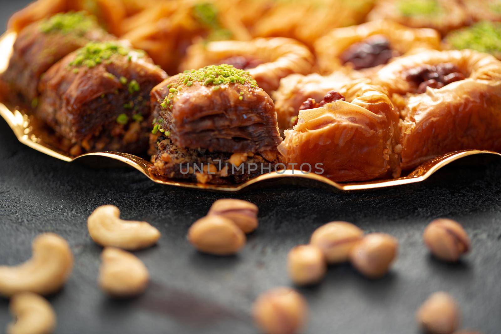 Delicious baklava dessert in oriental setting on black background, close up