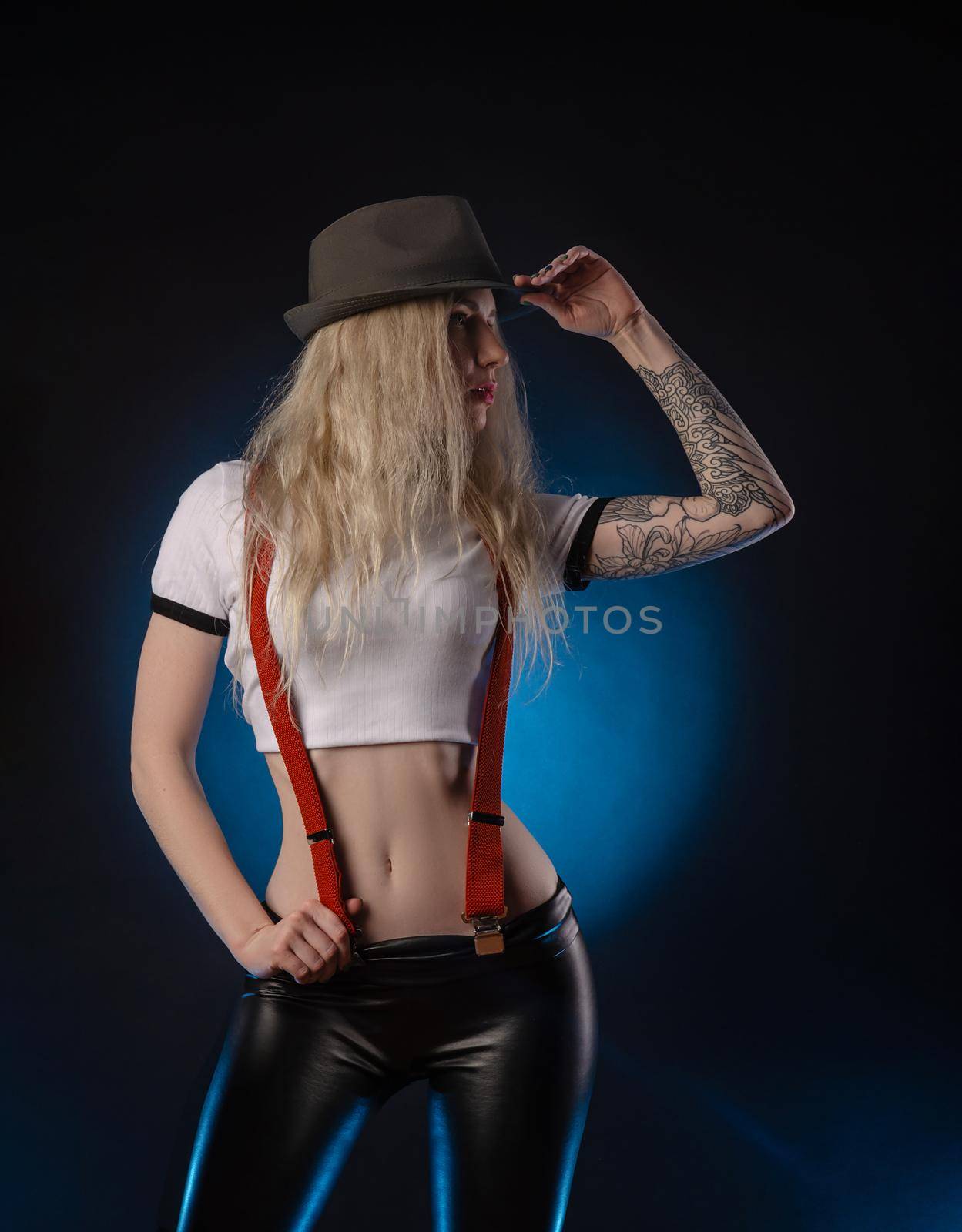 bright blonde in a hat against a dark background by Rotozey