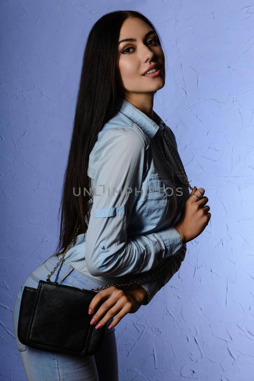 beautiful young woman posing at studioin jeans with bag by zartarn