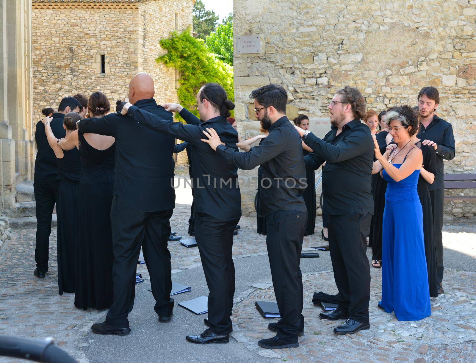 VAISON LA ROMAINE, FRANCE - AUGUST 4, 2016: Choral singers make a massage of each other before the performance. Relaxation.