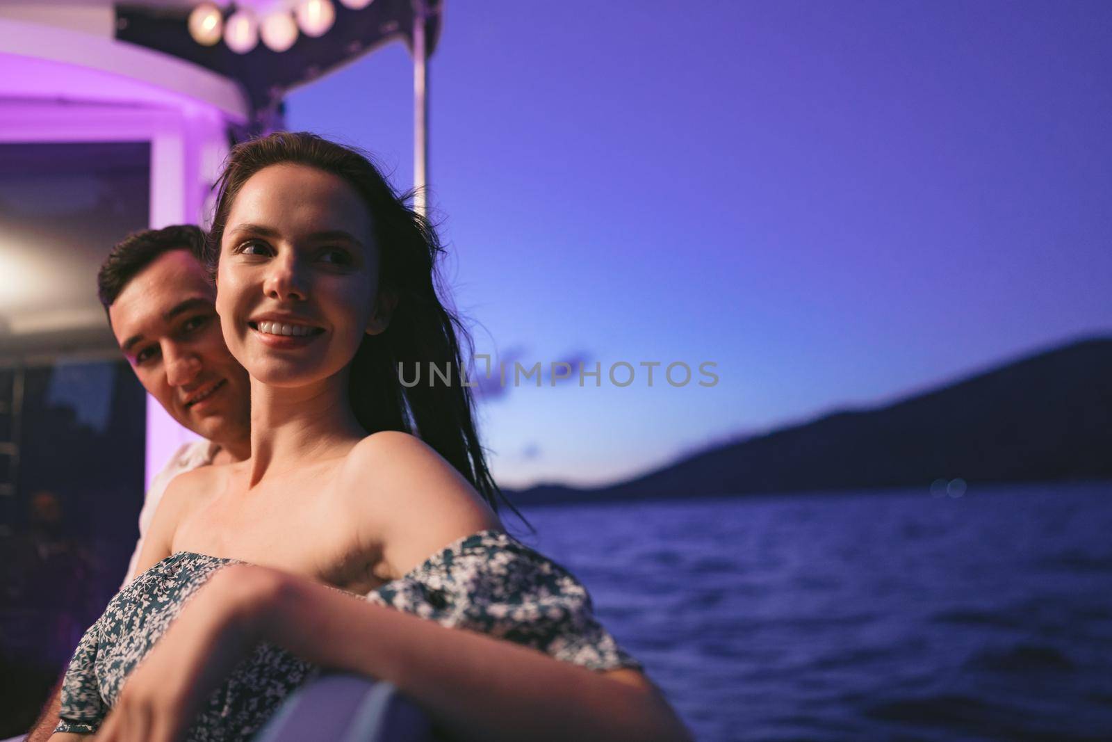 Portrait of happy loving couple on the yacht in the evening