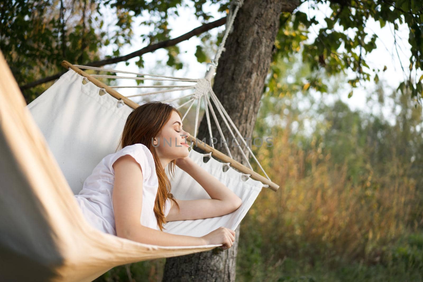 cheerful woman lies in a hammock outdoors nature vacation summer by Vichizh