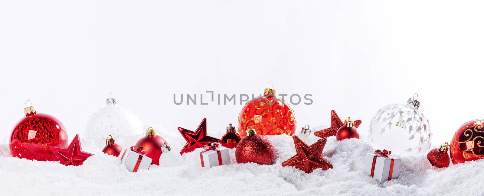 Christmas composition of red balls baubles stars on snow isolated on white background border frame design element