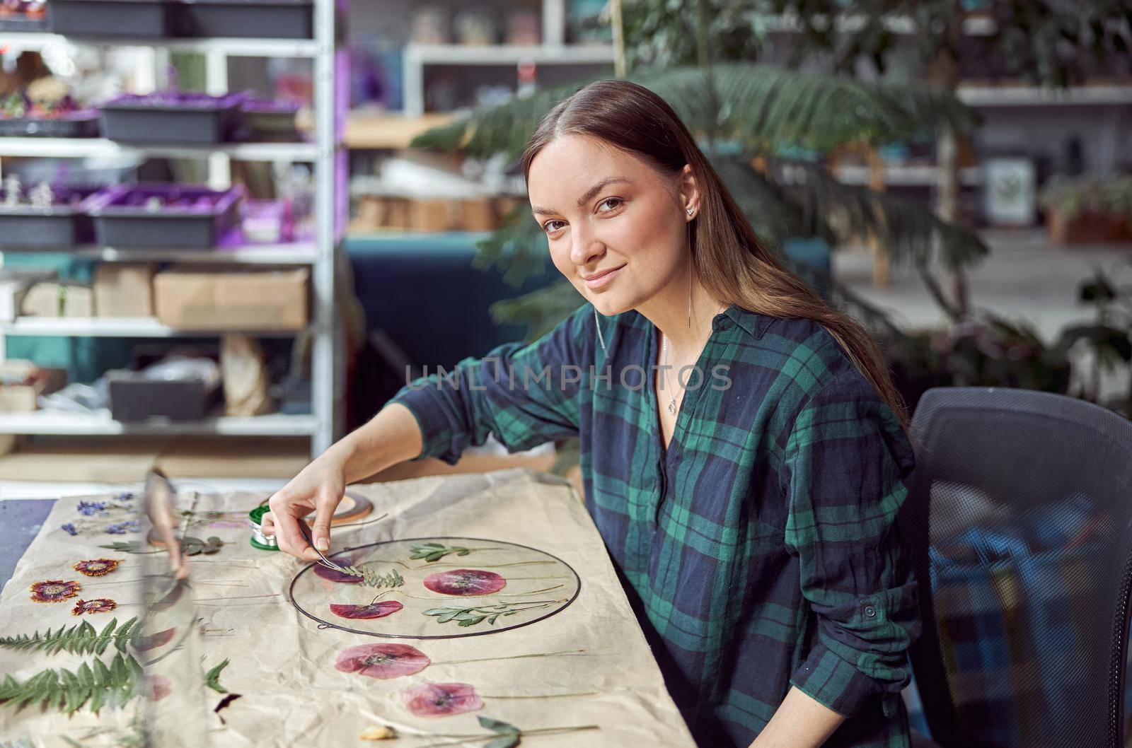 Confident female florist is working with dryed flowers in cozy flower shop