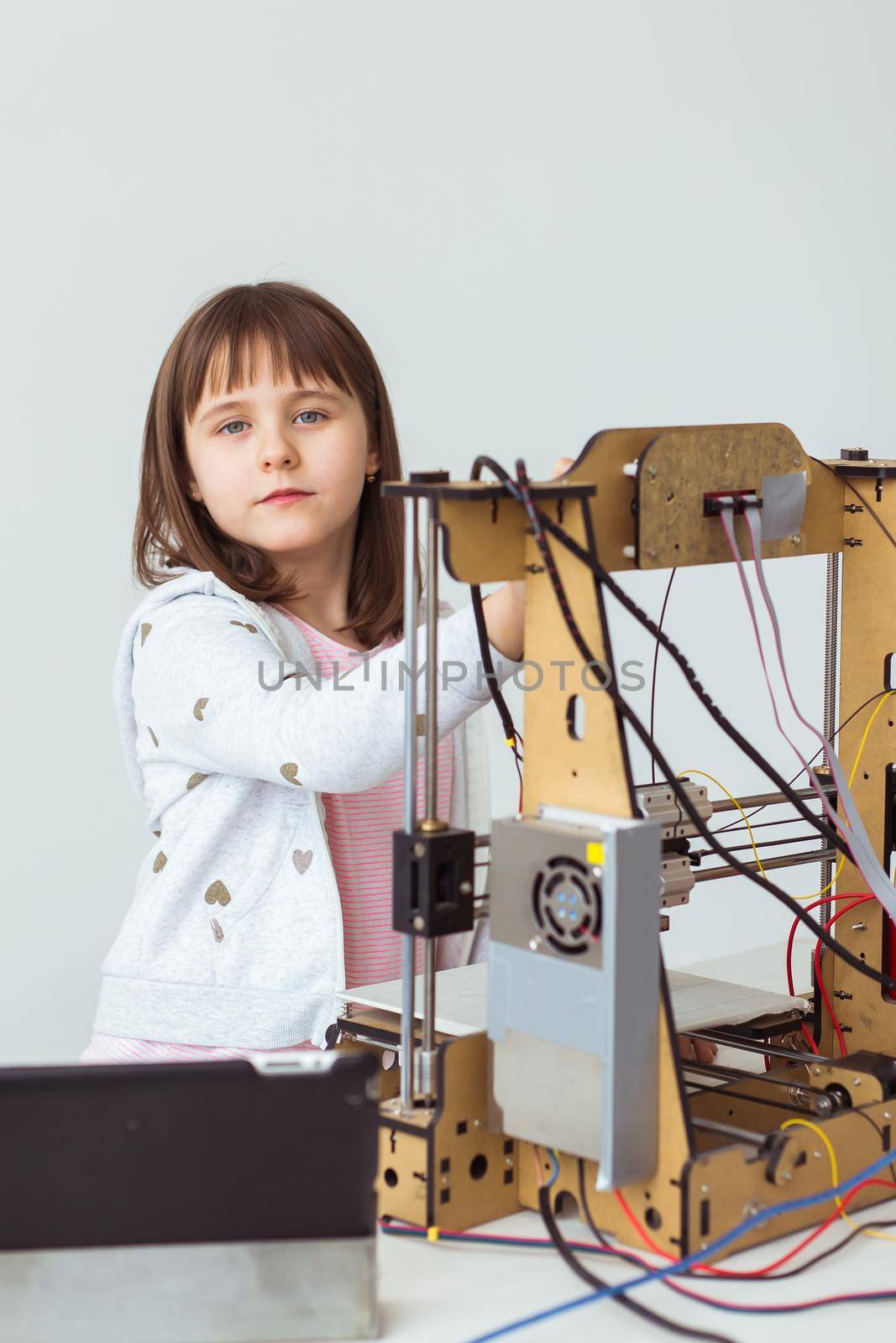 Cute girl with 3d printed shutter shades is watching her 3d printer as it prints her 3d model