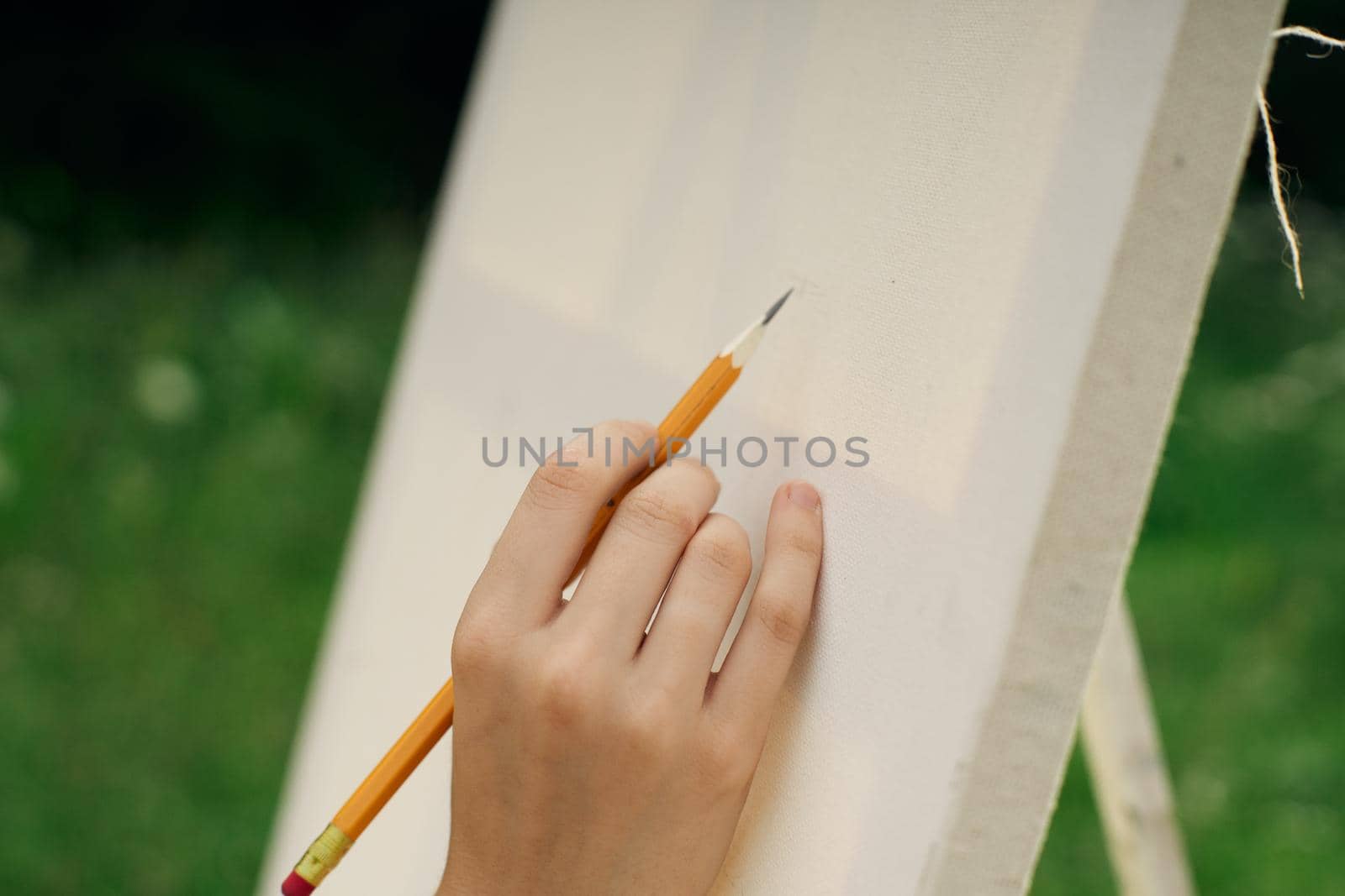 female hand with pencil easel drawing close up by Vichizh