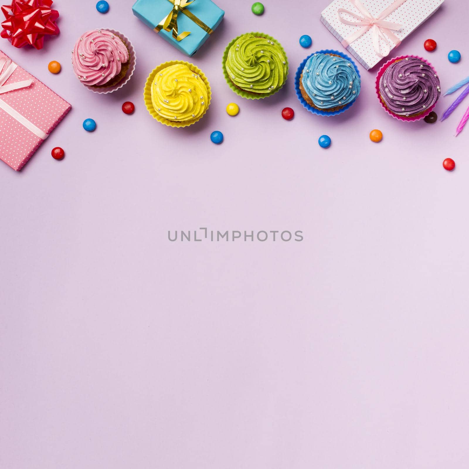 colorful muffins gems with wrapped gift boxes pink backdrop