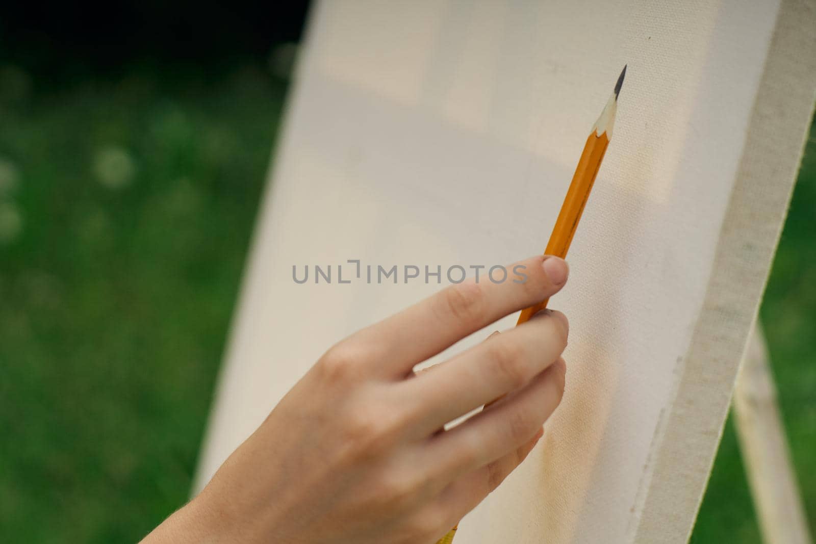 female hand with pencil easel drawing close up by Vichizh