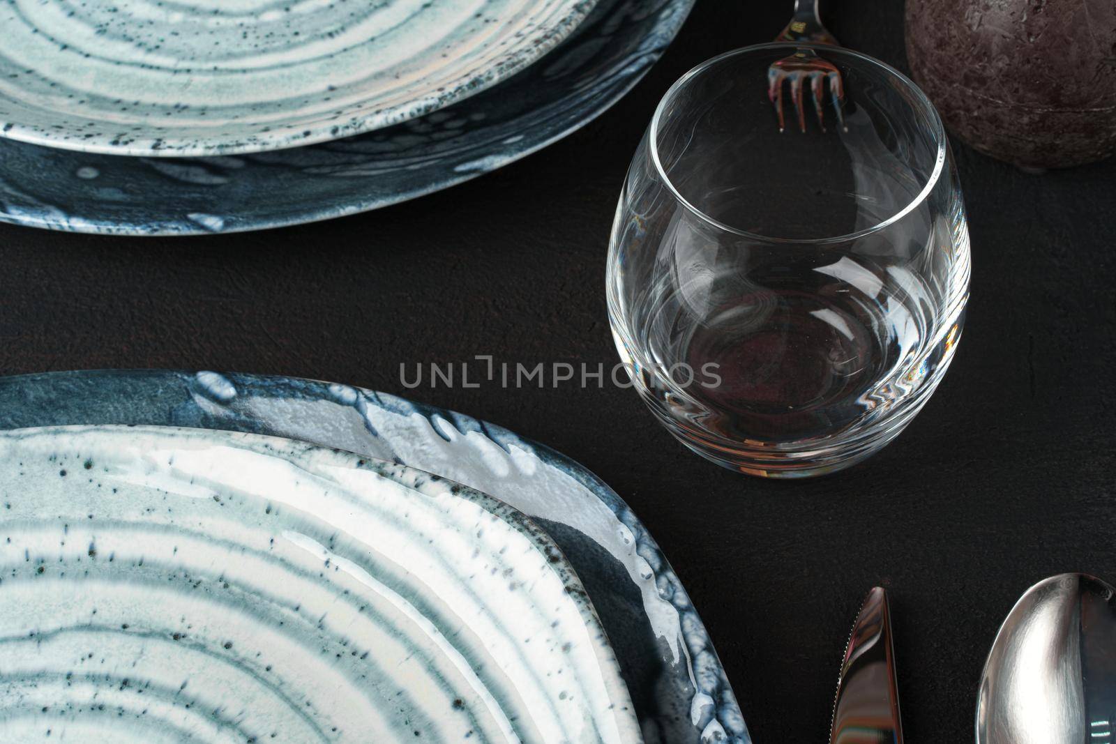 Table setting. Plates with abstract pattern on black table. High quality photo