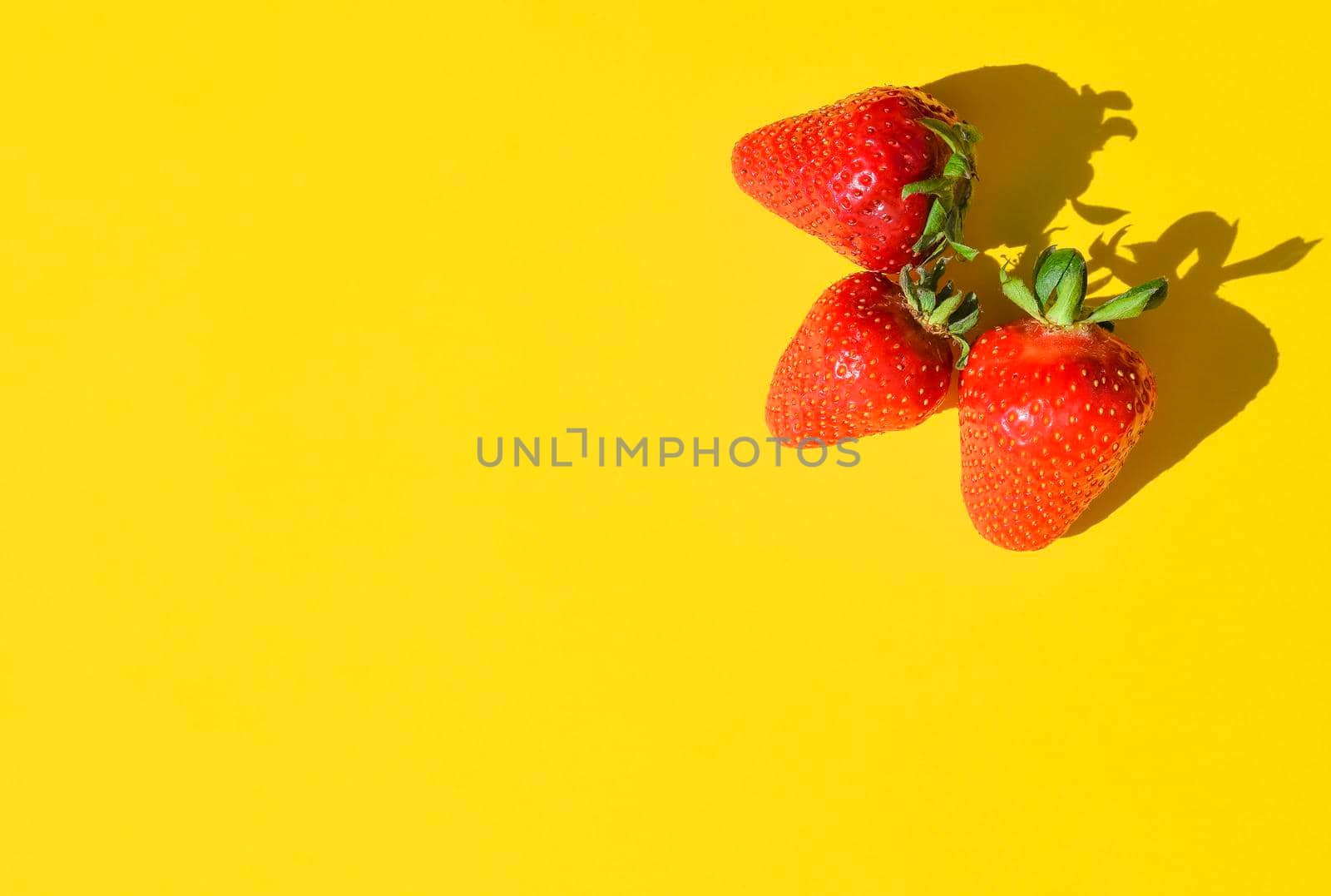 Fresh Strawberries close up. Strawberry isolated on bright yellow background