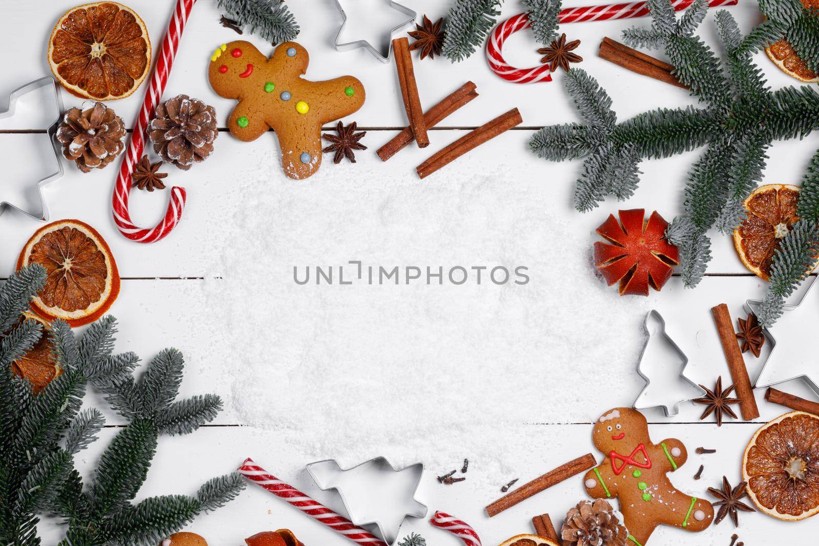 Christmas food frame. Gingerbread cookies, spices and decorations on wooden background with white copy space on white snow