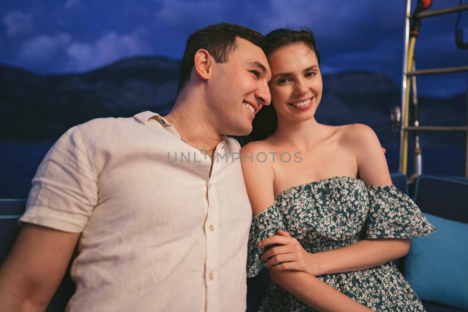Portrait of happy loving couple on the yacht in the evening