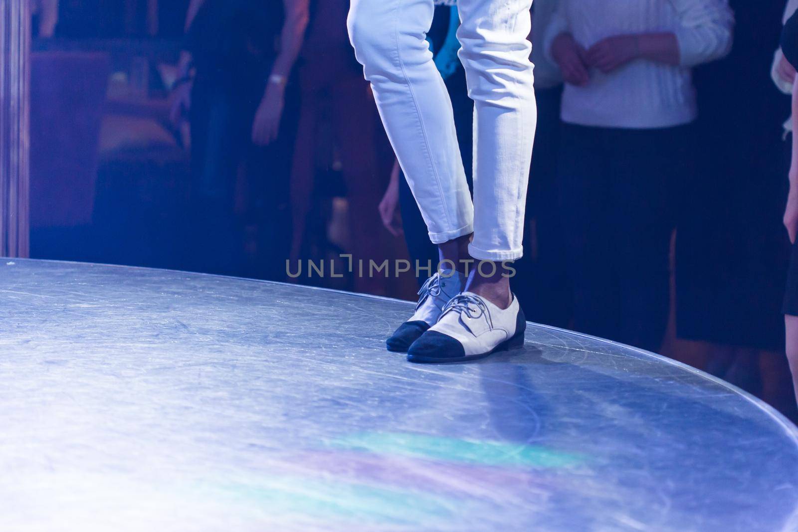 Dancing shoes feet and legs of male ballroom and latin salsa dancer dance teacher on the stage. Social dance, bachata solo and kizomba concept by Satura86