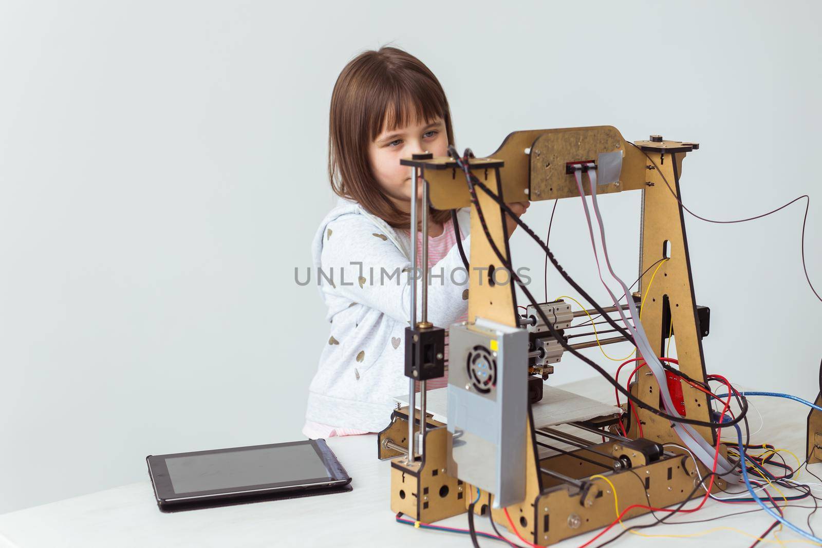 Little child architect using 3D Printer. Schoolgirl, technologies and study concept. by Satura86