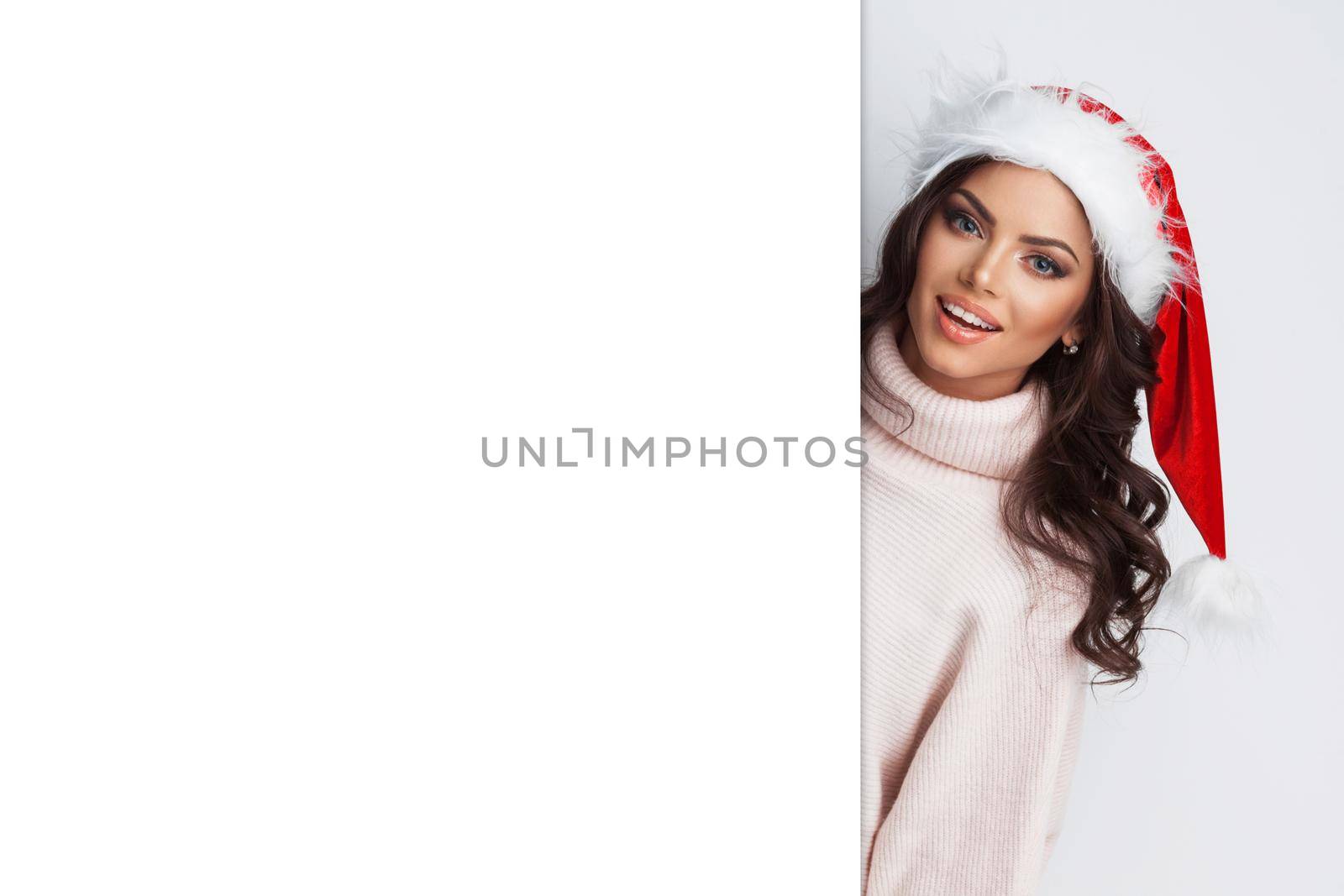 Christmas girl in santa hat with blank banner, isolated on white background