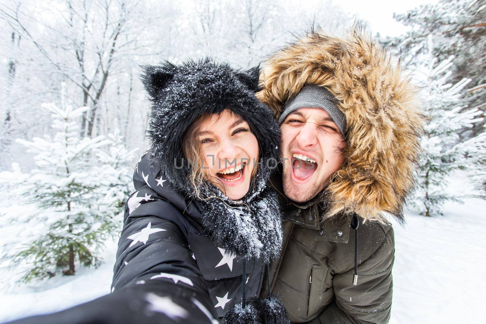 Season, love, technology and leisure concept - happy couple taking selfie by smartphone over winter background by Satura86