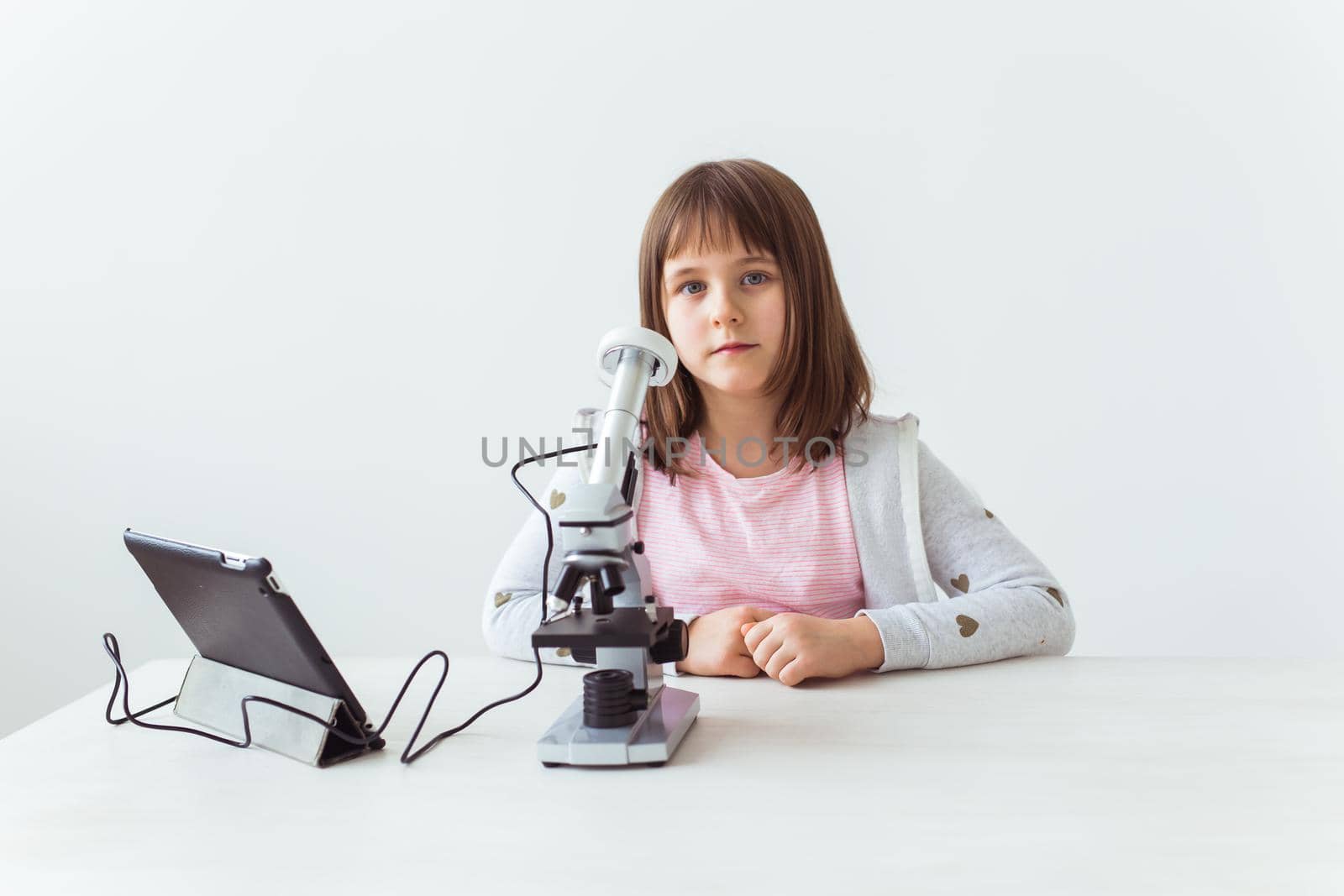 Child girl in science class using digital microscope. Technologies, children and learning concept. by Satura86