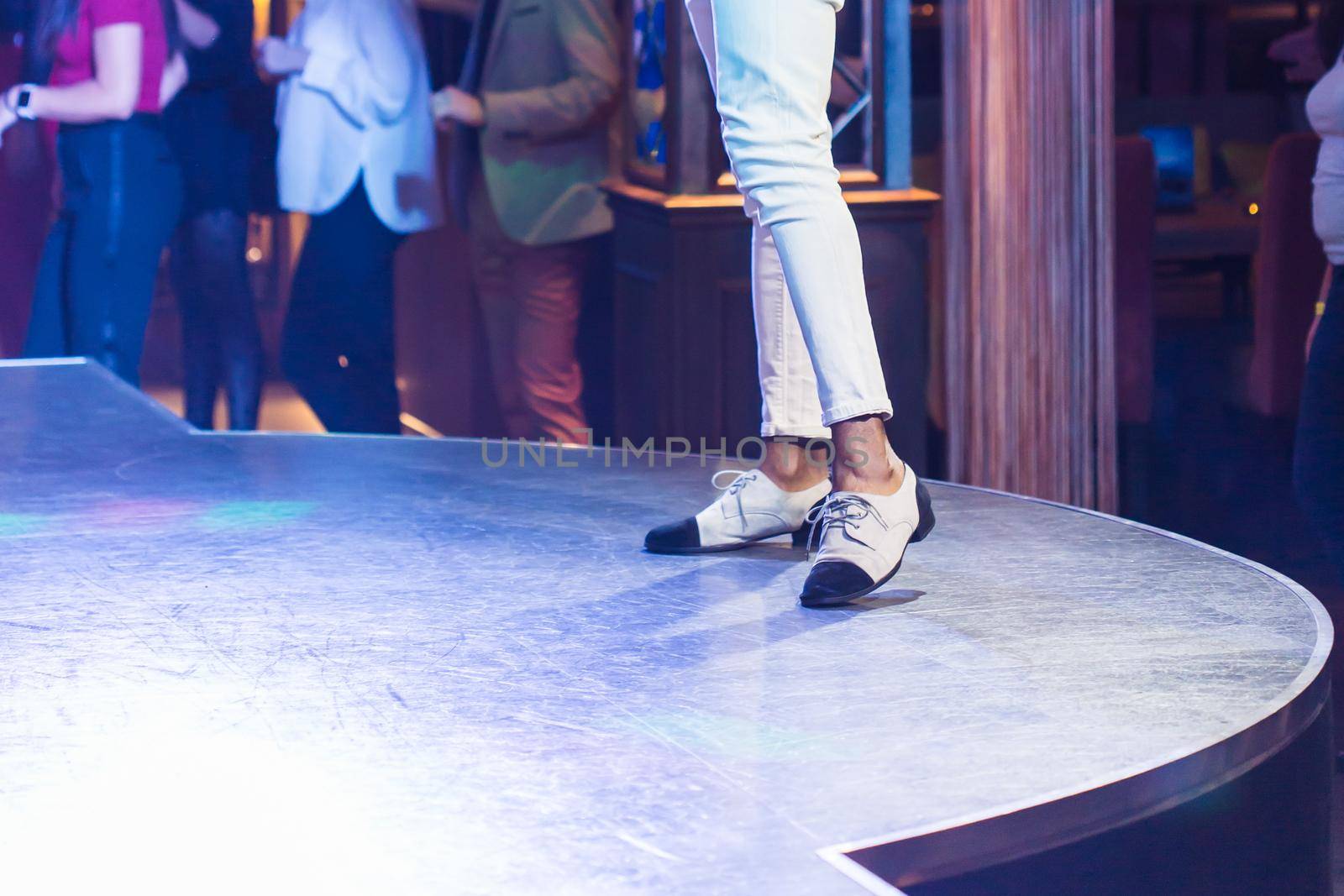 Dancing shoes feet and legs of male ballroom and latin salsa dancer dance teacher on the stage. Social dance, bachata solo and kizomba concept by Satura86