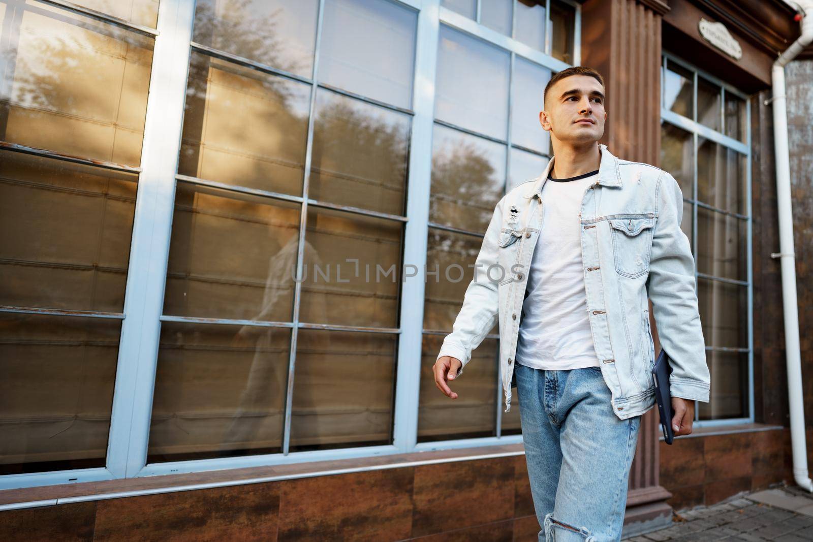 Portrait of handsome young casual man walking on the city street