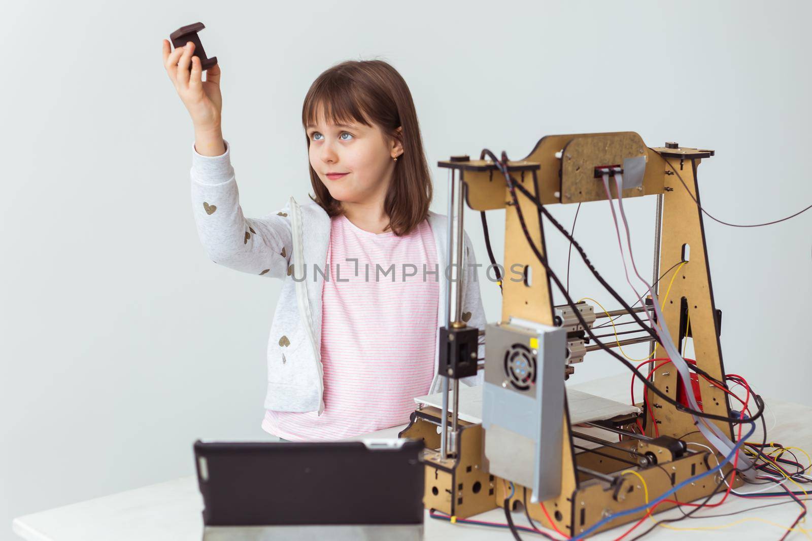 Little child architect using 3D Printer. Schoolgirl, technologies and study.