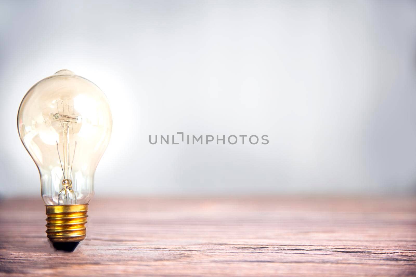 Lightbulb shining on wooden shelf with copy space, idea and creative concept background, dea and Creative concept for startup new project. Technology object and Electrical part theme. Energy and Power saving theme. modern