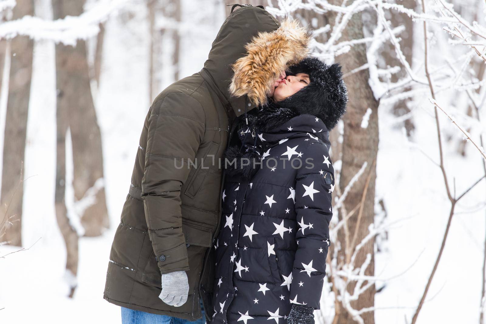 Young couple walking in a snowy park. Winter season