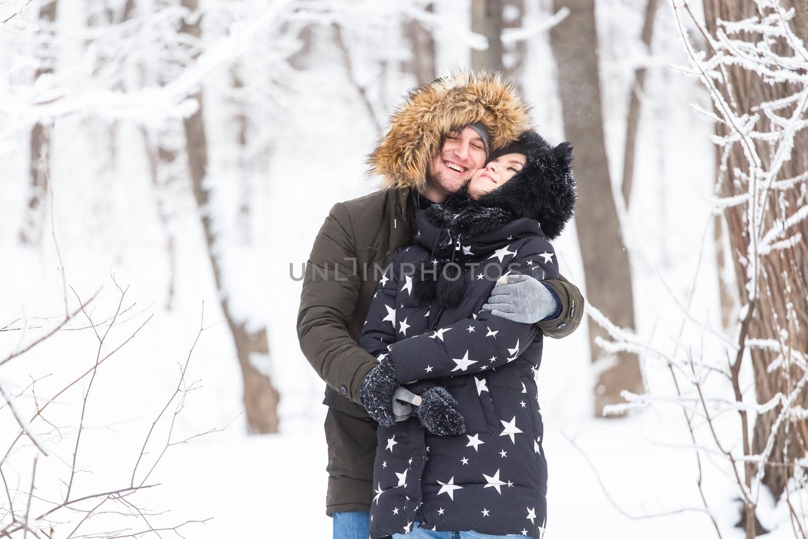 Young couple have fun in a snowy park. Winter season. by Satura86