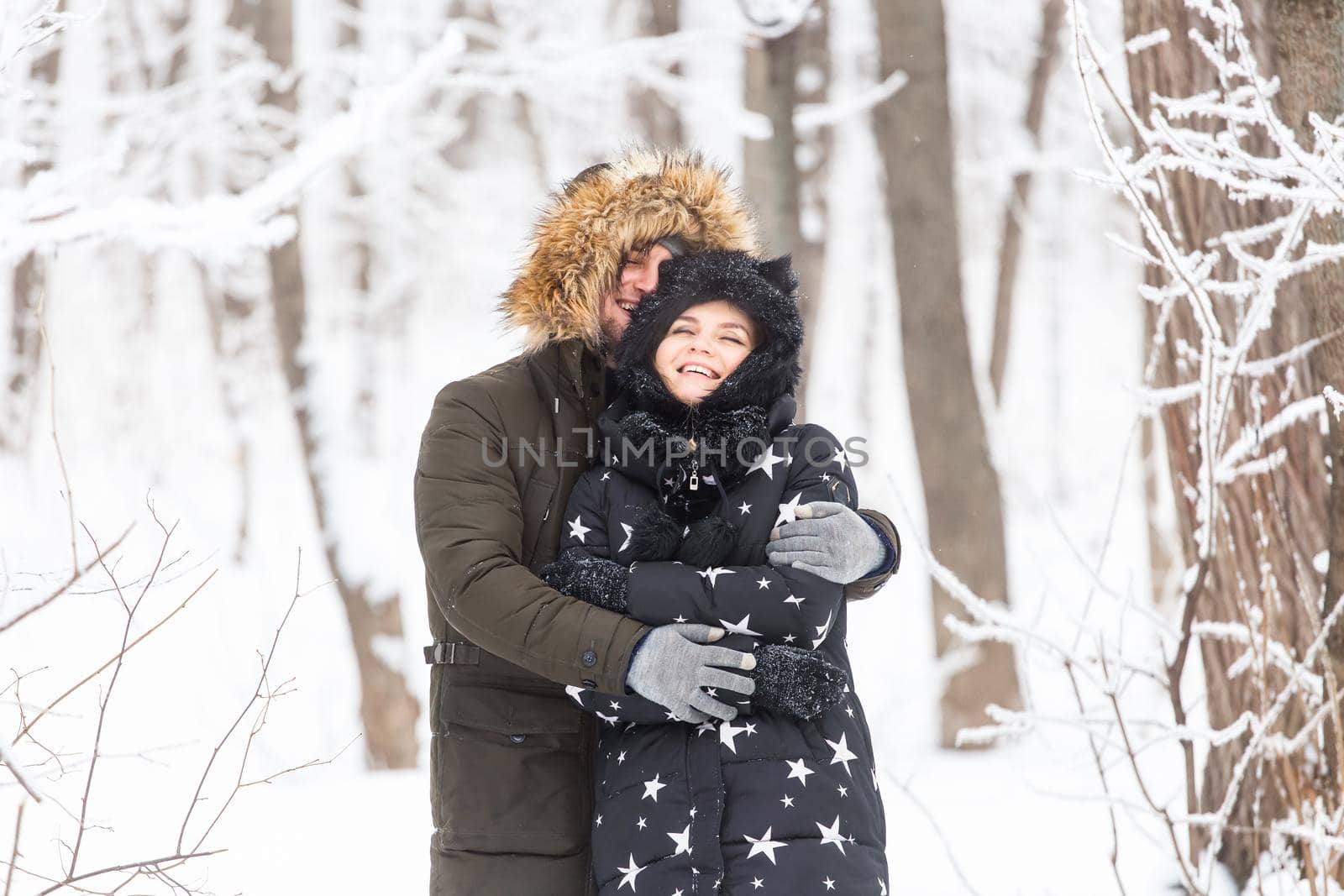 Young couple have fun in a snowy park. Winter season. by Satura86