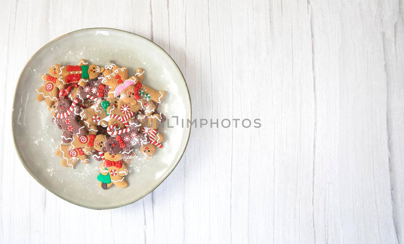 Christmas cookies,gingerbread man cookies with powdered sugar on natural plate, white wooden background texture,homemade top view copy space