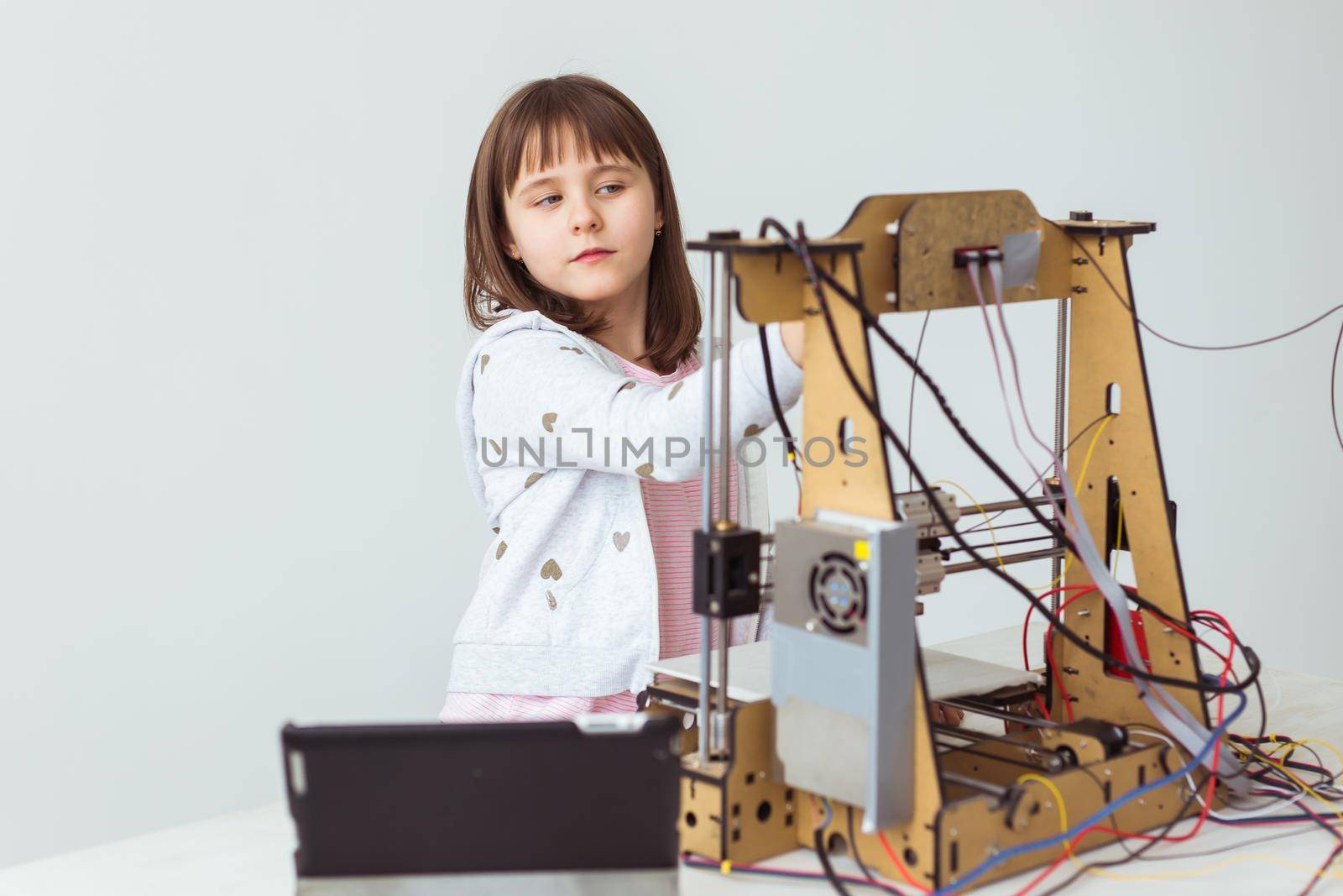 Little child architect using 3D Printer. Schoolgirl, technologies and study.