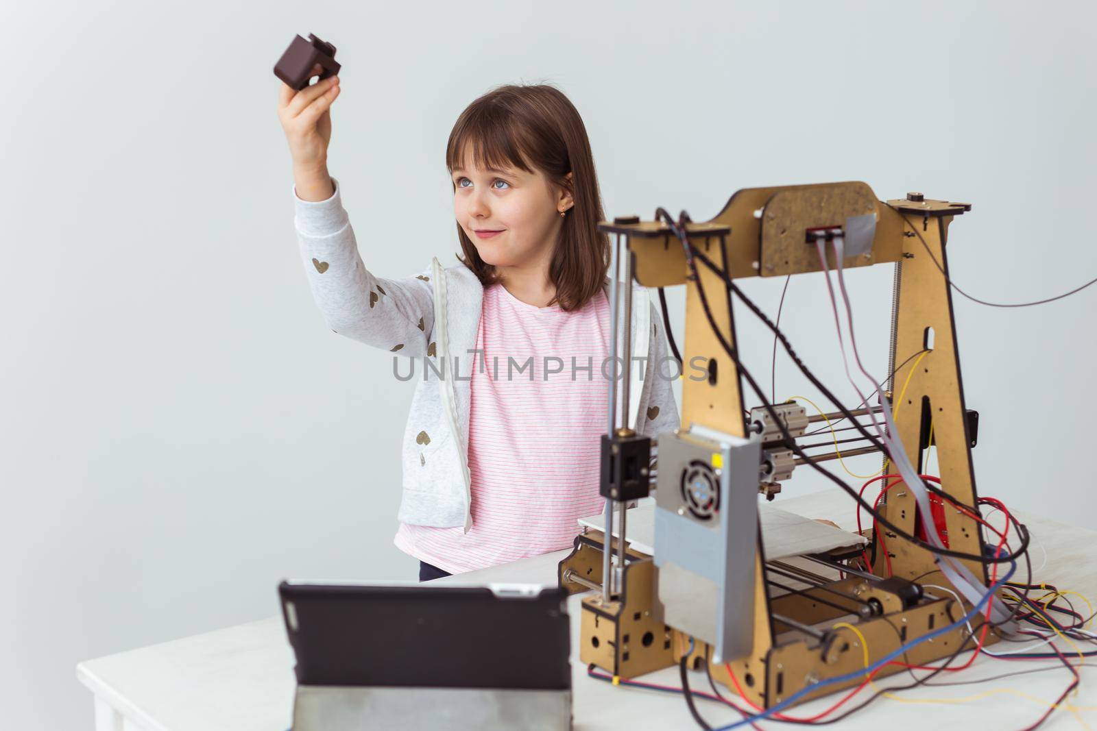 Child student makes the item on the 3D printer. School, technologies and science concept. by Satura86