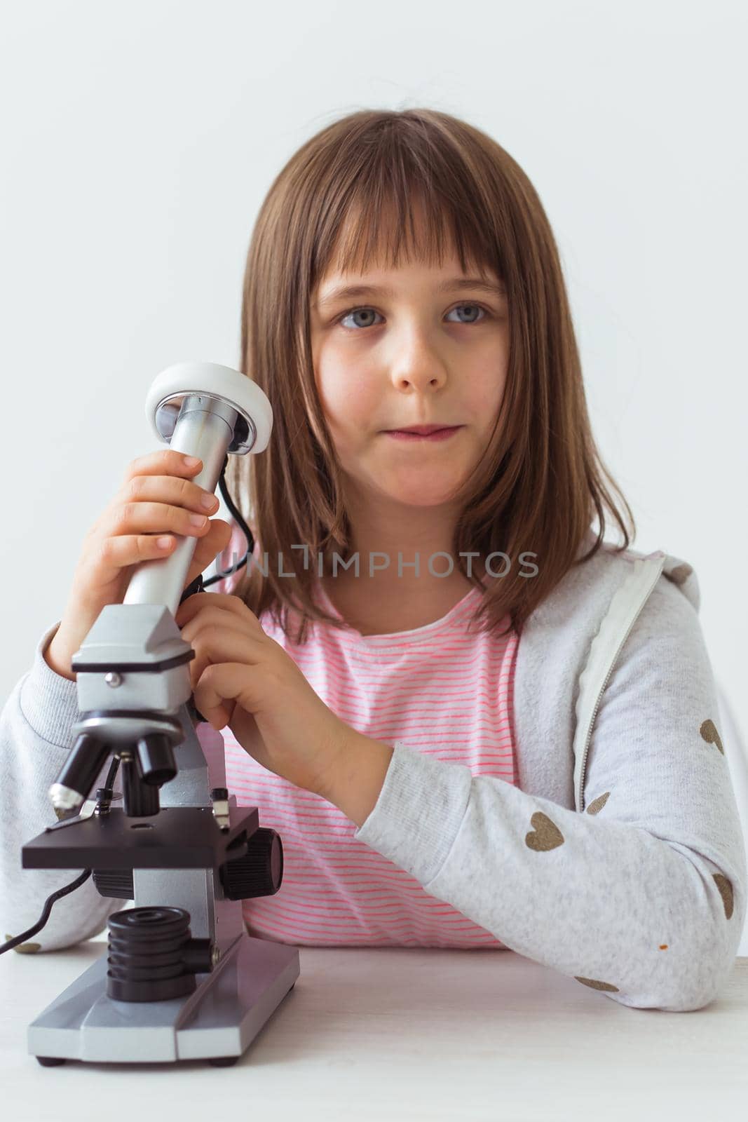 Child girl in science class using digital microscope. Technologies, children and learning concept. by Satura86