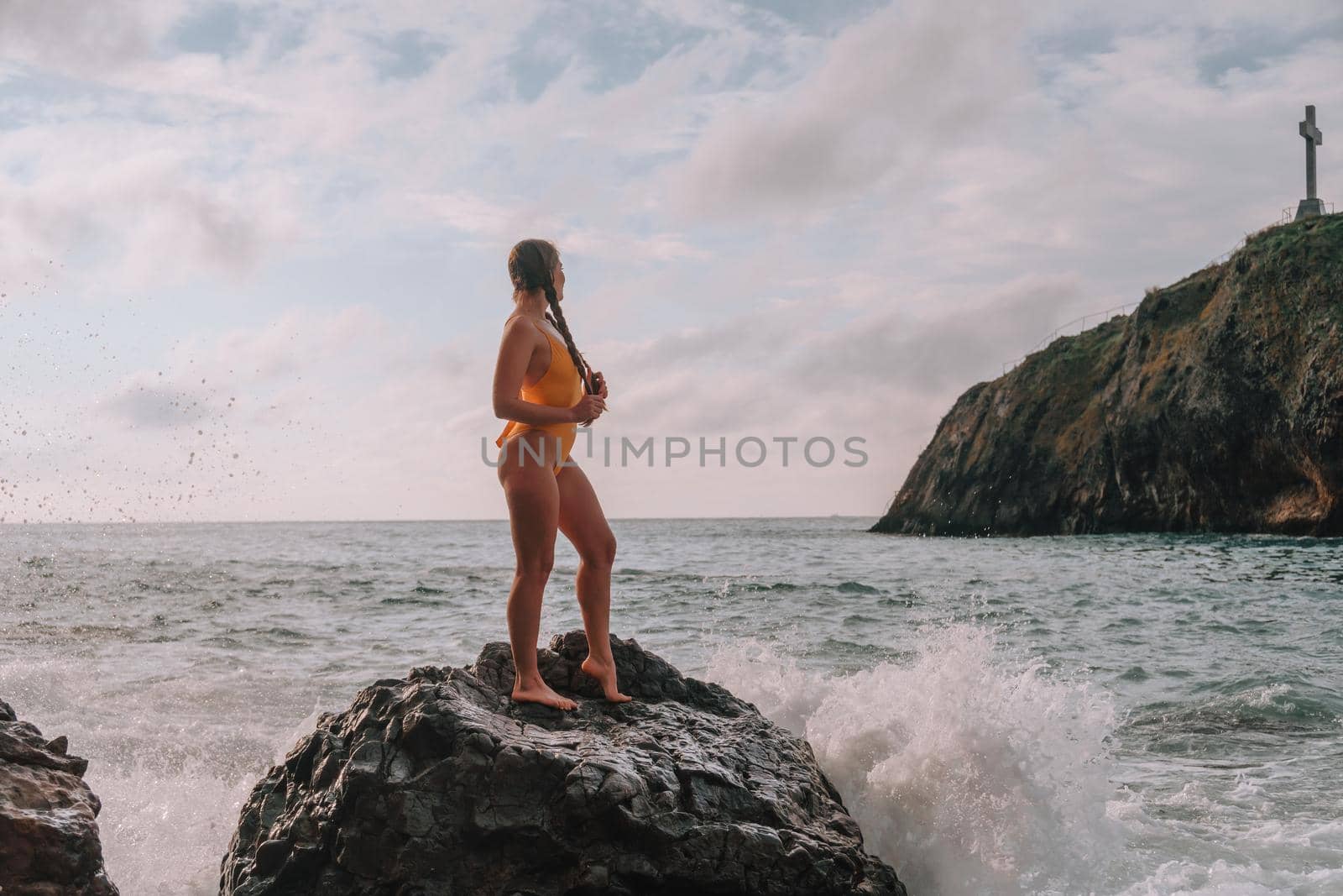 Selective focus. Happy carefree sensual woman with long hair in black swimwear posing at sunset beach. Silhouette of young beautiful playful positive woman outdoor. Summer vacation and trip concept by panophotograph