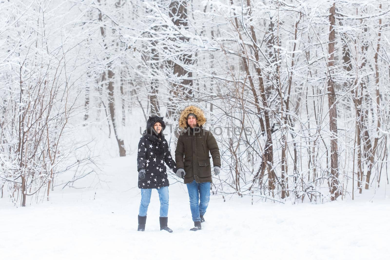 Young couple in love walks in the snowy forest. Active winter holidays. by Satura86