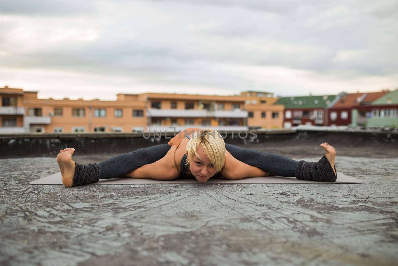Woman practicing yoga on the roof, Upavista konasana